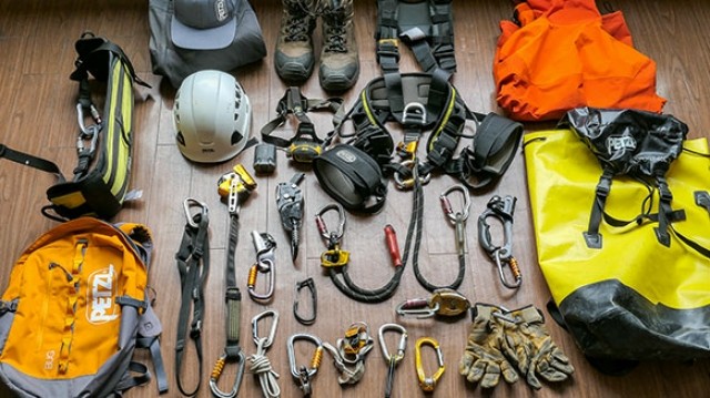 Dit is een rope access klimset met karabiners, slings, tassen, een gordel, een helm, een zitje, schoenen, cowtails, mobiele valbeveiliging en afdaalapparaten.